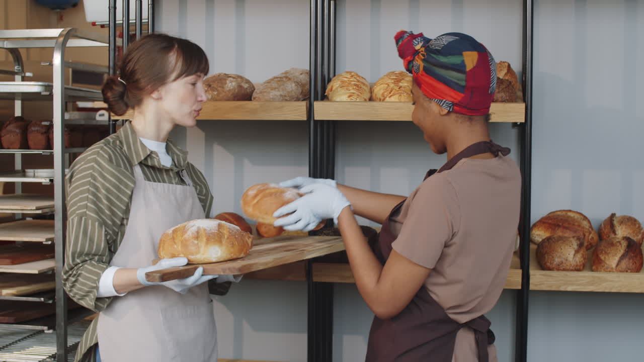 Multiethnic Women Smiling and Chatting during Workday in Bakery