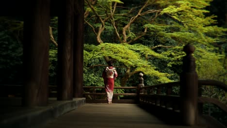 woman in kimono walking through a japanese temple garden