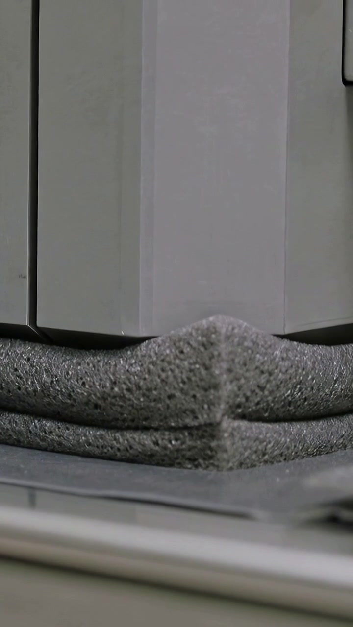 Vertical video: Signaling platen lowering, pressing stacked foam pads at lab rig for press test