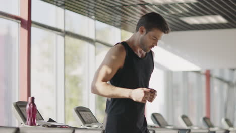 Fitness-man-running-on-treadmill-machine-in-gym-club.