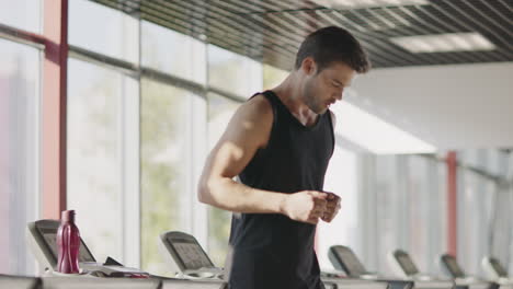 fitness man running on treadmill machine in gym club.