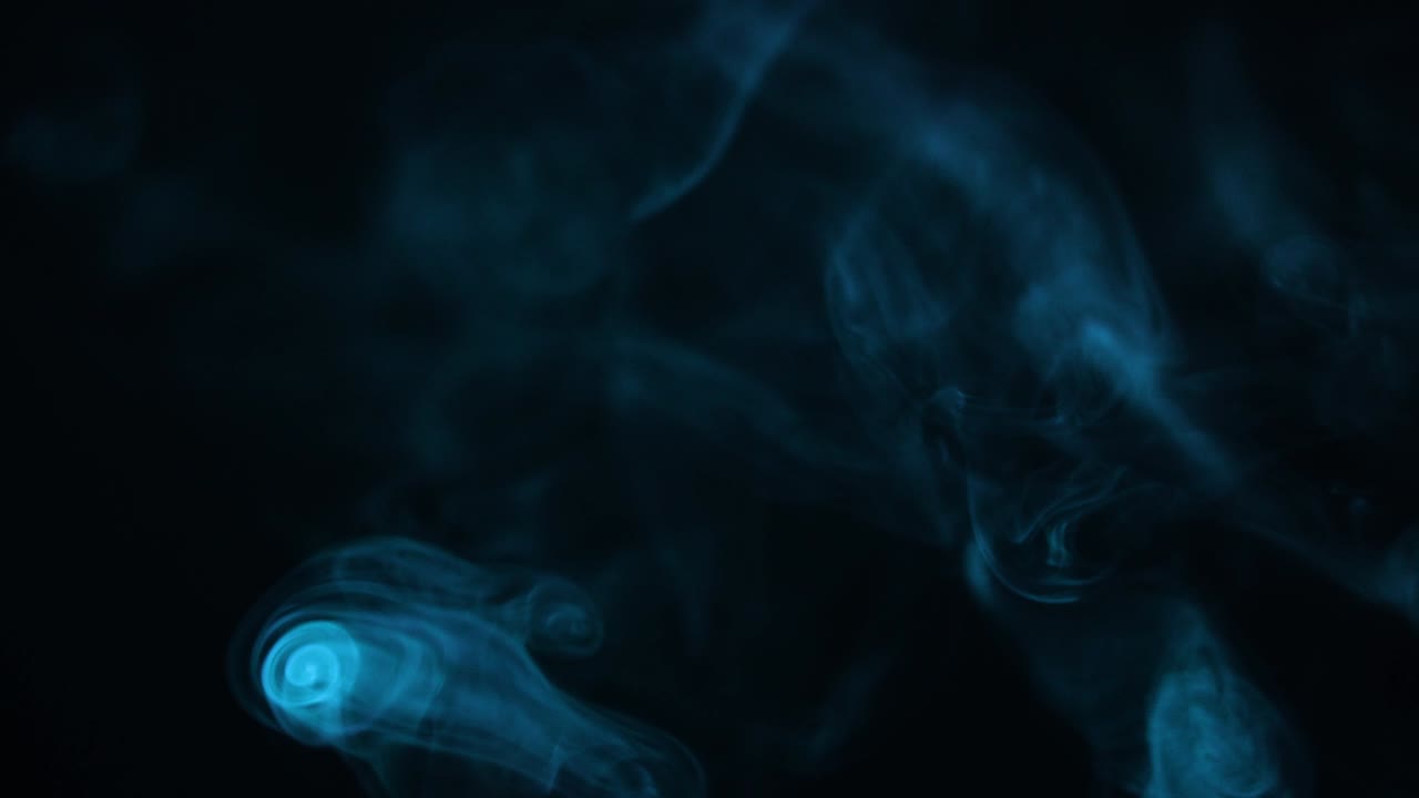 느린 동작으로 파란색 연기가 흐르고 어두운 배경에서 추상적인 증기가 흐르고 있습니다.