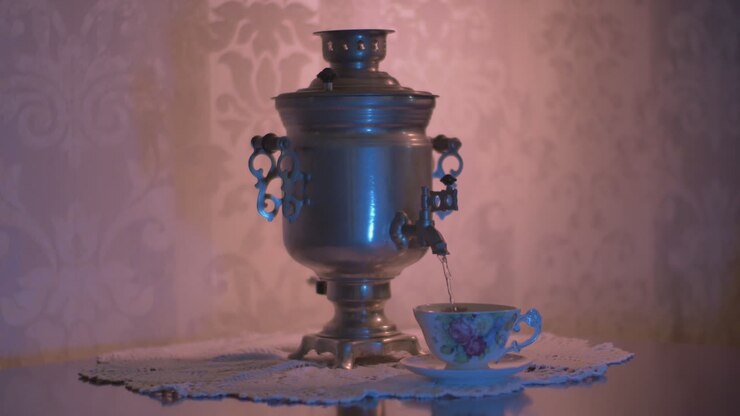 Hælder varmt vand fra en sovjetisk vintage samovar elektrisk metalt tekedel ned i en smuk kop-1.