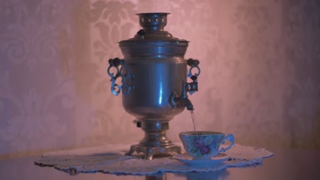 pouring hot water from a soviet vintage samovar electric metal tea kettle into a gorgeous cup-1