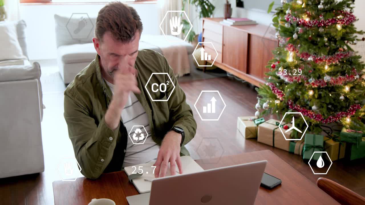 Mature man typing on laptop at desk generating sustainability icons around laptop reviewing metrics