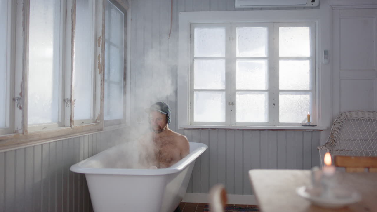 Caucasian man climbs into steaming bath in shabby chic room, wellness concept
