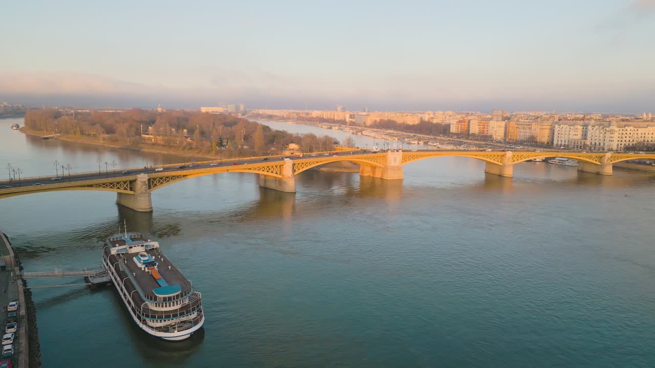 Spettacolari riprese con drone che panoramano intorno al Ponte Margherita a Budapest, Ungheria, al tramonto.