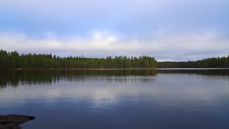 Tiro-De-Lapso-De-Tiempo-Sobre-Un-Gran-Lago-Con-Un-Bosque-En-La-Orilla-Opuesta