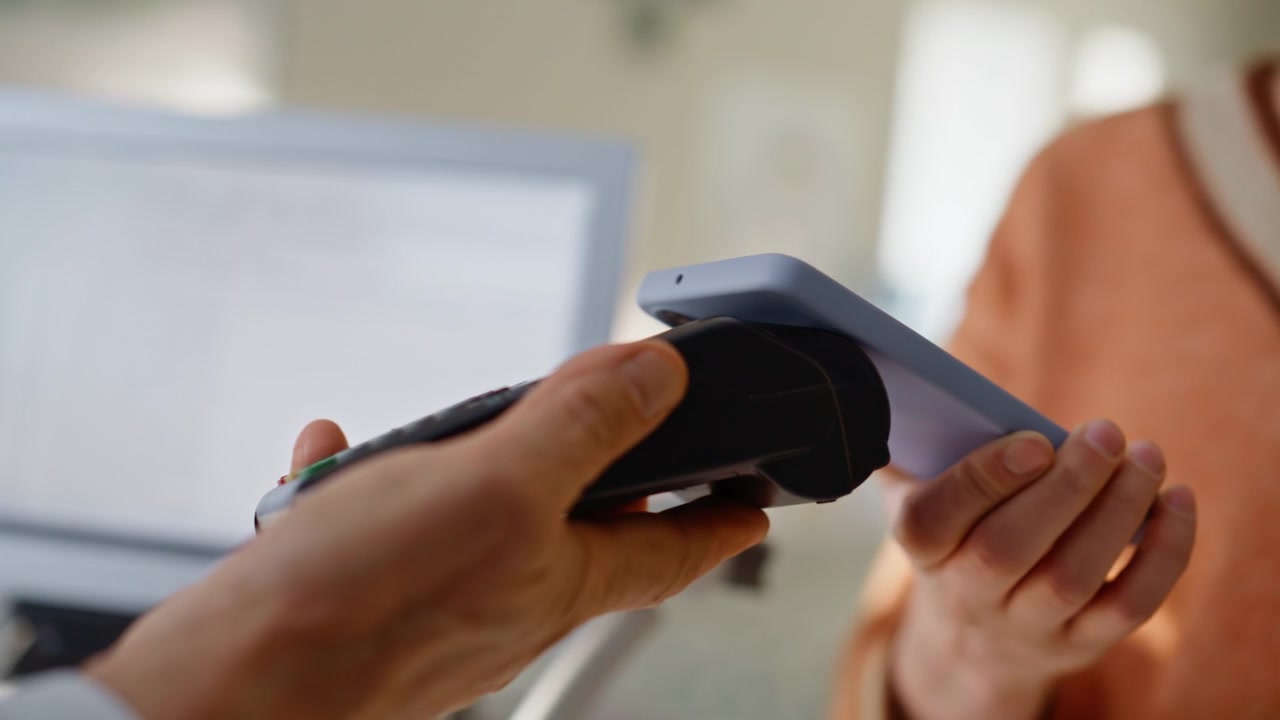 Seller fingers typing terminal machine entering payment details client closeup