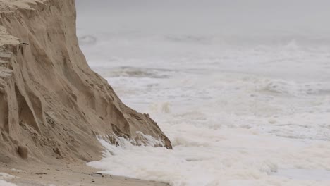 un video de 13 segundos que muestra la erosión costera en broadbeach, con olas chocando contra acantilados de arena bajo cielos nublados
