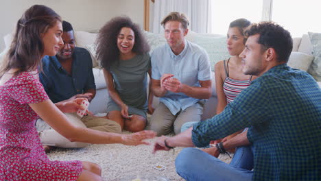 grupo de amigos en casa jugando a las cartas juntos