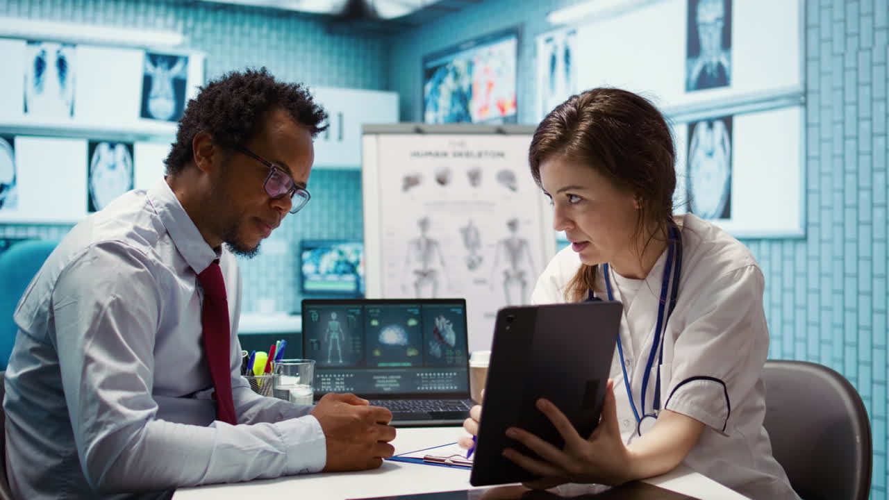 Physician comforting her male patient by holding his hand and giving her support