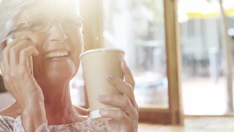 Glückliche-ältere-Frau,-Die-Beim-Kaffeetrinken-Am-Telefon-Spricht-4k-4k