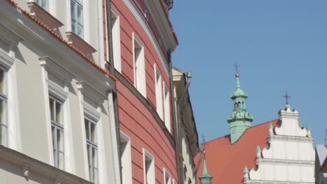 slow motion pan shot of typical polish buildings and a church on a sunny day