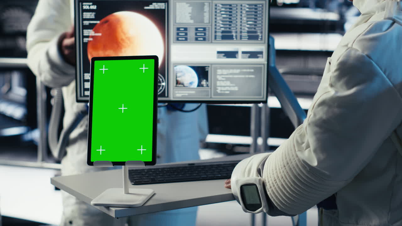 Astronauts reviewing onboard analytics on isolated screen tablet