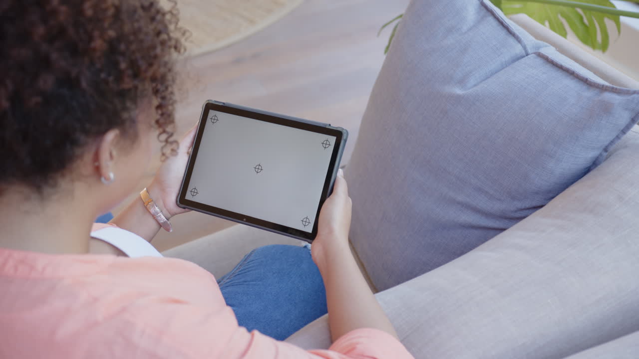 Holding tablet, woman relaxing on couch at home, copy space