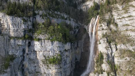 drone view of famous seerenbachfälle waterfall during sunny day in amden, switzerland