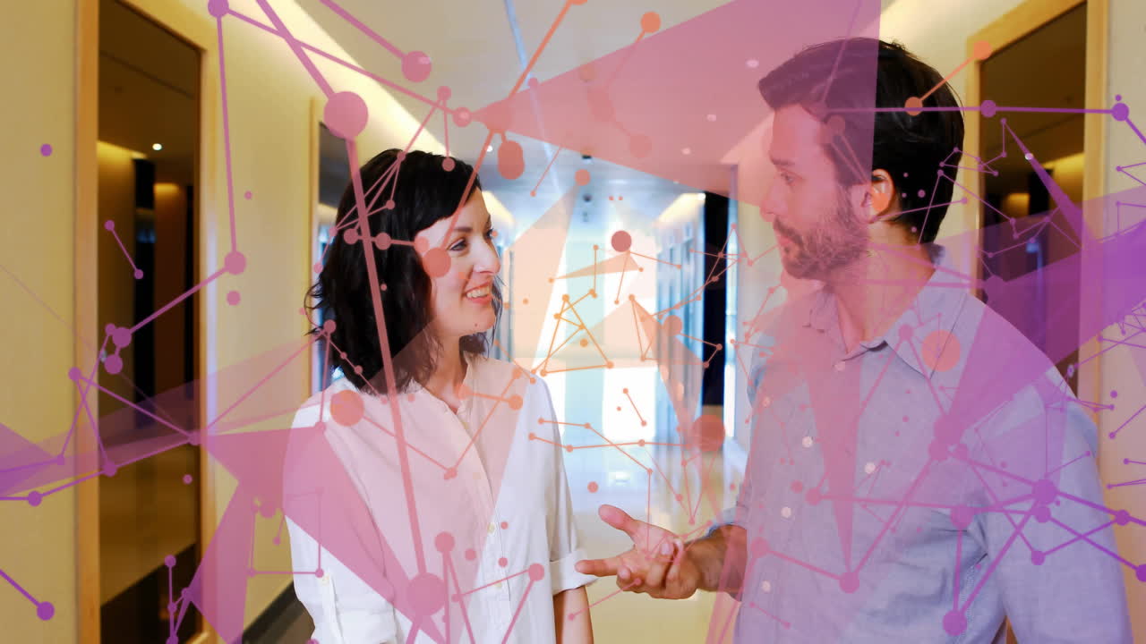 Two people talking in hallway with abstract pink network animation overlay