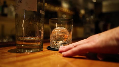 person placing glasses on bar counter sequentially