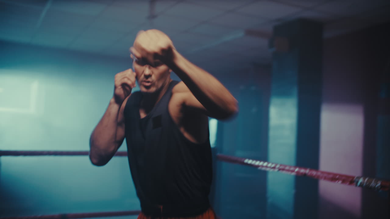 Male boxer training in a boxing ring