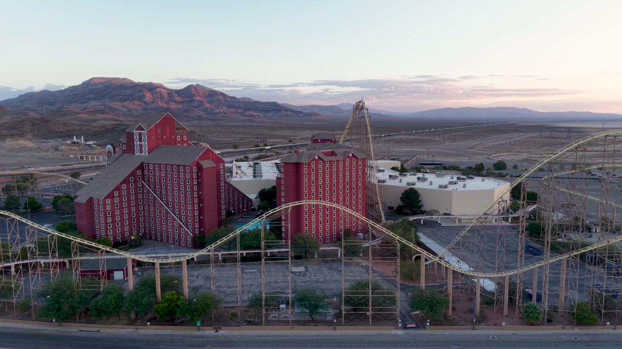 Luftoptagelse i kredsløb af den forladte hotelkasino- og rutsjebaneattraktion ved grænsen mellem Californien og Nevada. Dronen afslører den enorme størrelse af denne engang populære forlystelse og den store Nevada-ørken bagved.