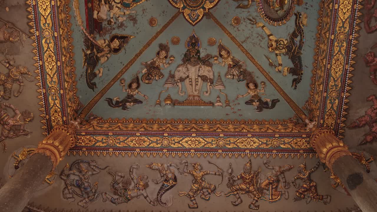 смотря на красочные религиозные картины и резьбы внутри памятника победы патуксай в центре вьентьяне, лаос