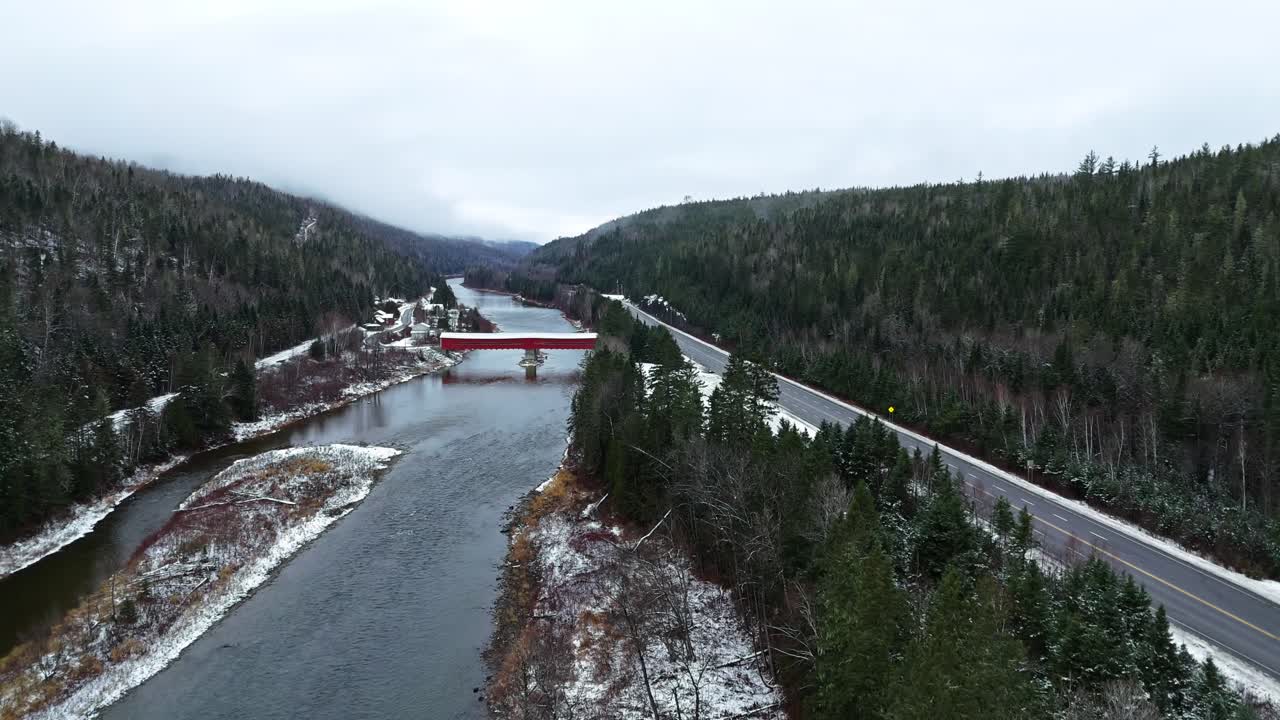 puente cubierto con un poco de nieve cruzando un río en quebec, canadá