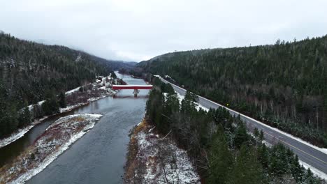 covered-bridge-with-a-little-bit-of-snow-crossing-a-river-in-quebec,-canada