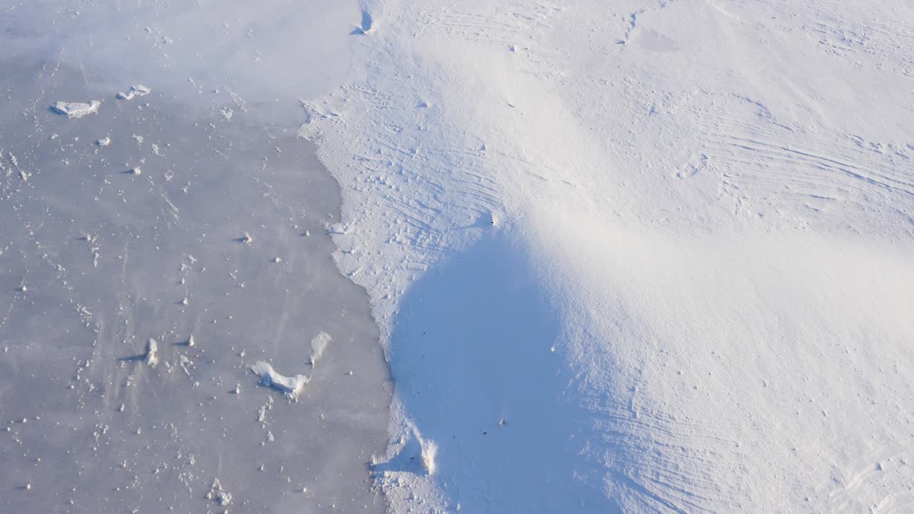 Smukt vinterlandskab, isdækket flod dækket af fygesne, vinterkulde, vinterbaggrund.