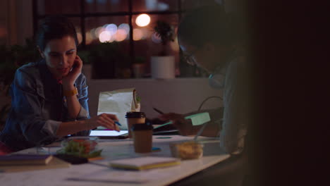 business people working late marketing team designing company logo female entrepreneurs brainstorming ideas planning creative project deadline in office at night