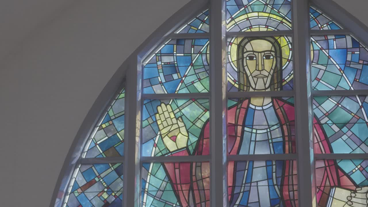 Colorful church window with an image of Jesus Christ