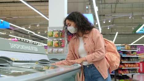 woman shopping for frozen foods in supermarket during pandemic