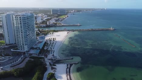 aerial footage of puerto cancun beach area, aerial of hotels on the oceanfront with clear blue ocean waters