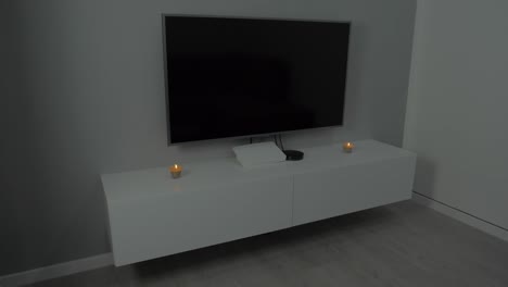 modern minimalist living room with wall mounted tv and candles