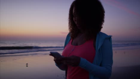 voluptuous african american female exercising with smart phone