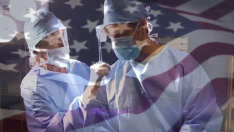 Animation-of-flag-of-usa-waving-over-surgeons-in-operating-theatre