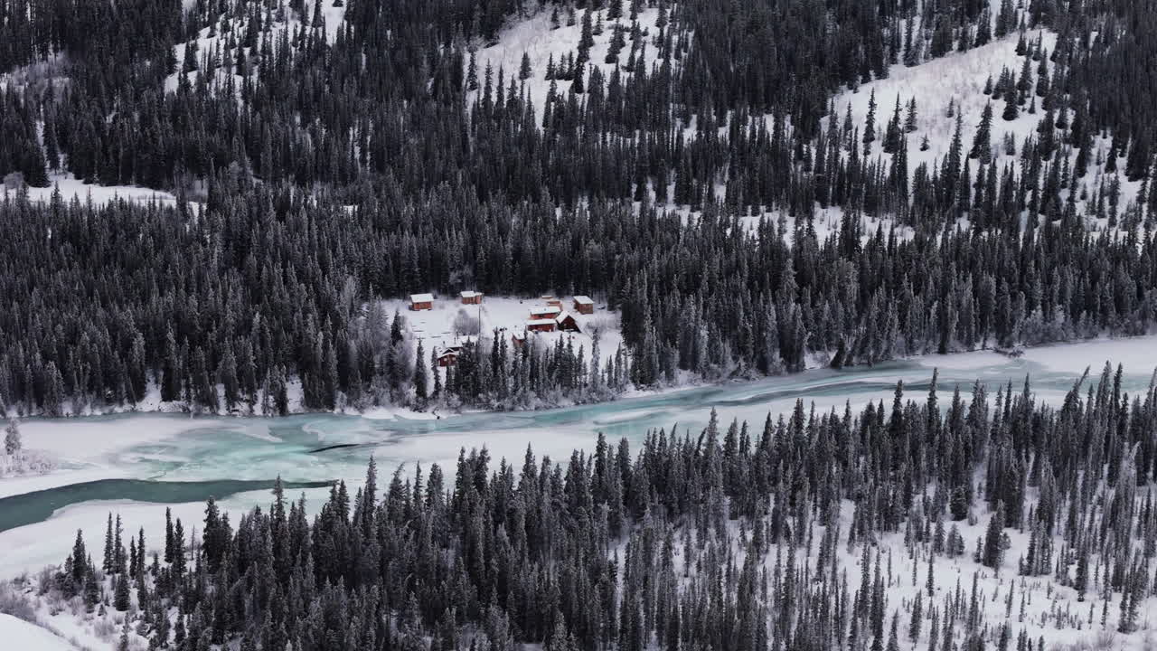 Takhini River Surrounded By Snowy Fir Forest In Yukon, Canada. aerial shot