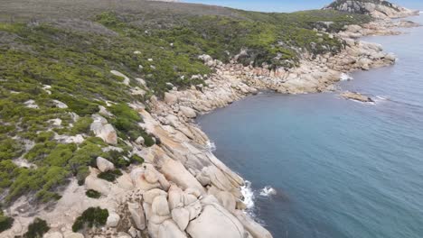 drone aerial rising and pan down over beautiful blue water and white rocks on a sunny day in wilsons promontory