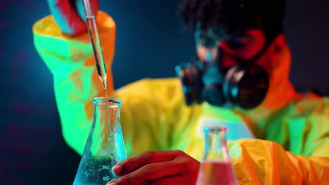 científico arrojando líquido químico transparente con pipeta química en el laboratorio de tubos, experimento peligroso en el laboratorio de cuarto oscuro