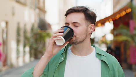 Glücklicher-Mann-Genießt-Morgens-Einen-Heißen-Kaffee-Und-Lächelt-Entspannt,-Macht-Eine-Pause-Auf-Der-Stadtstraße