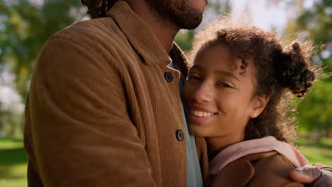 Portrait-african-american-daughter-looking-camera.-Unknown-dad-hold-kid-in-arms.