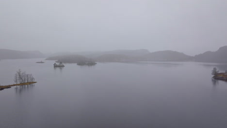 lago calmo envolto por nuvens e neblina