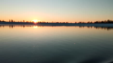 puesta de sol de invierno sobre un río congelado