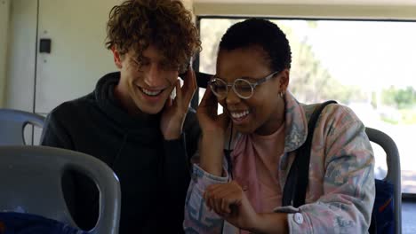 pareja escuchando música en auriculares mientras viajan en el autobús 4k