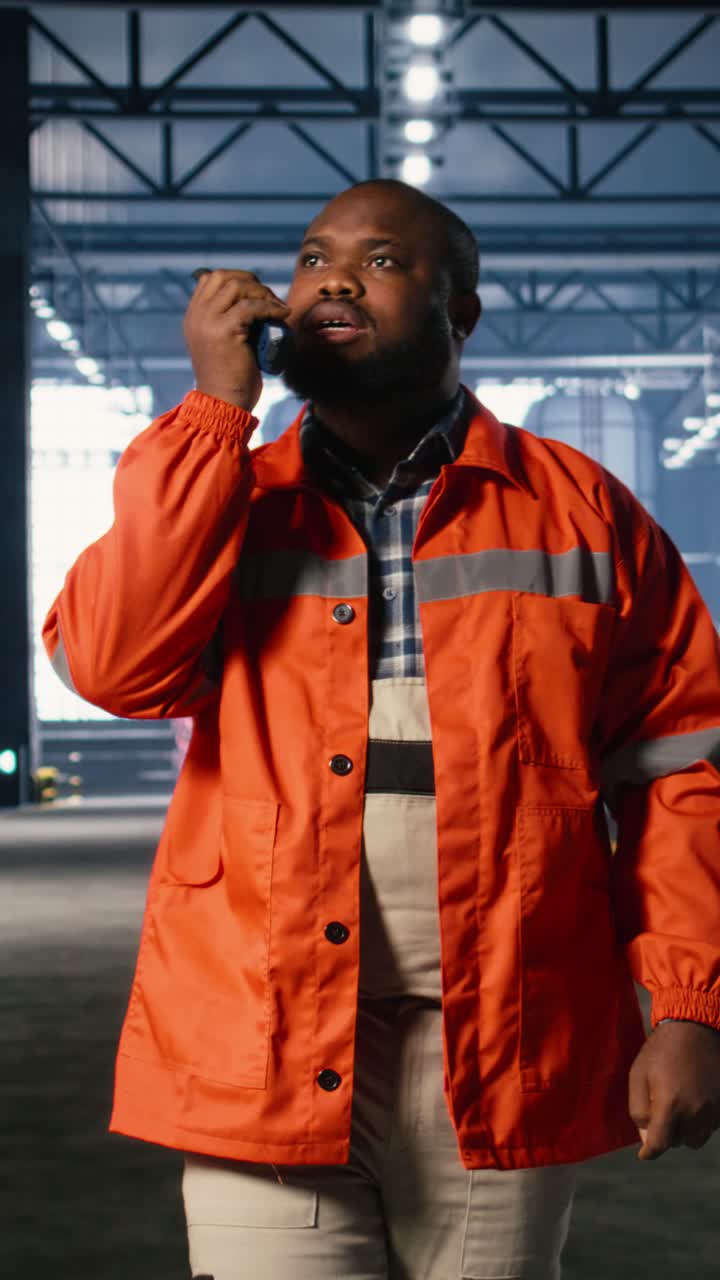 Vertical Video Black worker uses walkie talkie radio to guide colleague personnel