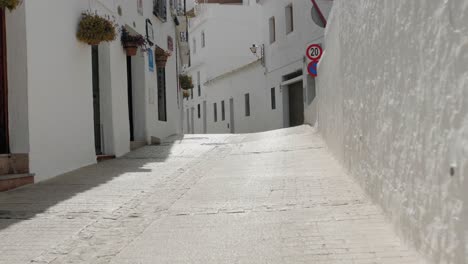 zoom en cámara lenta de una calle blanca de pueblo mediterráneo durante un día soleado