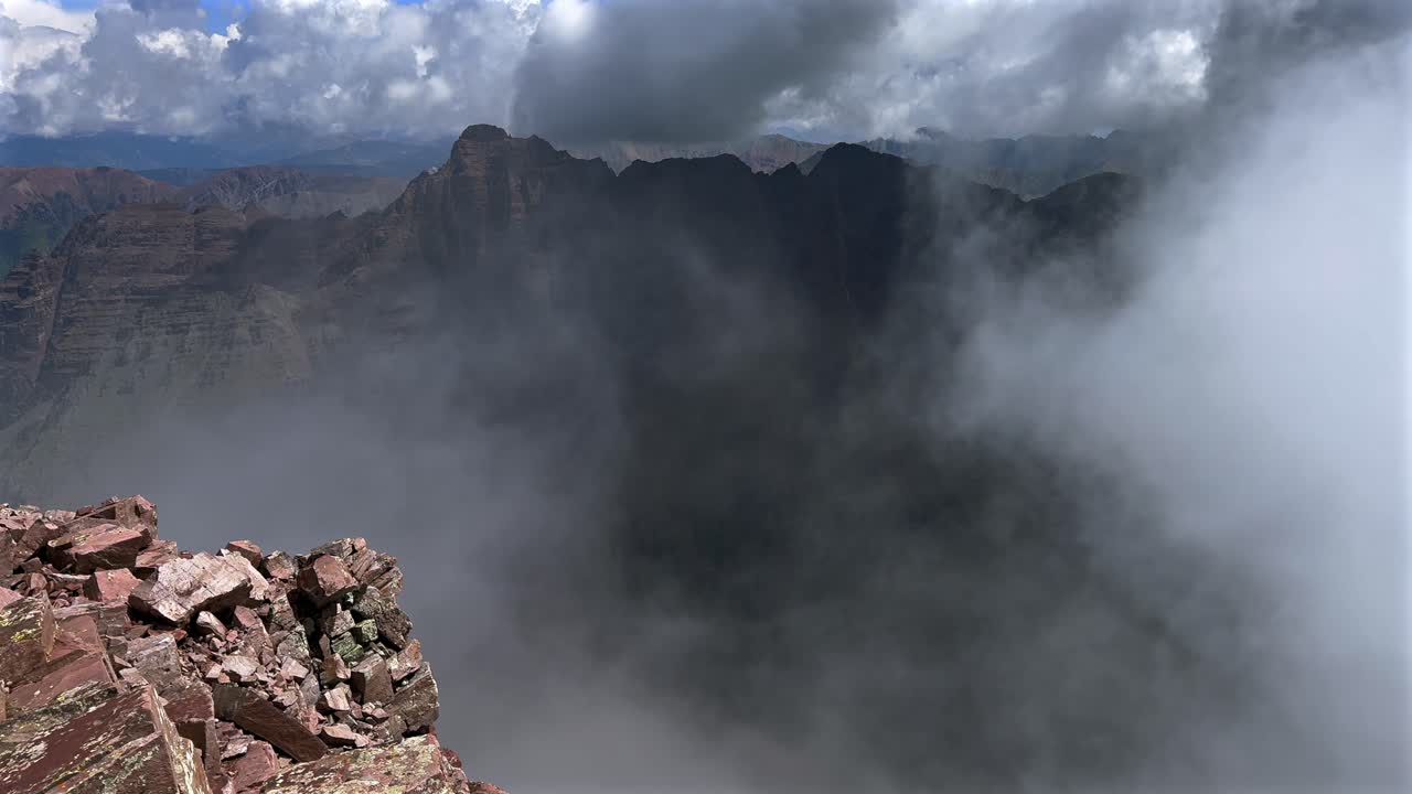 Pyramid Peak Aspen Snowmmass summer aerial drone fog stormy weather clouds Maroon Peak Maroon Bells Wilderness hiking fourteener Colorado Elk Range Rocky Mountains rugged terrain pan left