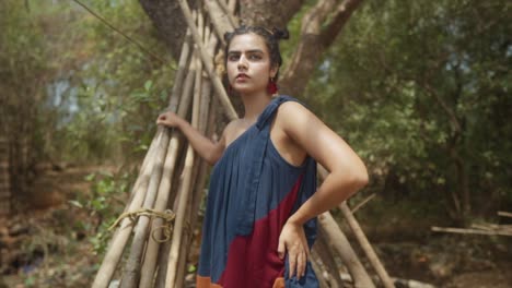 Imagen-Cinematográfica-En-Cámara-Lenta-De-Una-Modelo-India-Posando-Con-Un-Vestido-De-Moda-Sostenible-Azul,-Rojo-Y-Naranja-En-El-Bosque-De-Goa,-India,-Slomo