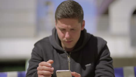 unhappy man using mobile phone on street