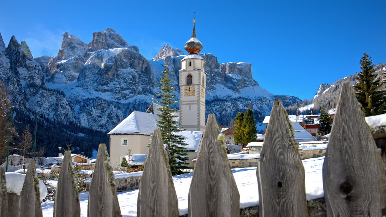 View of the Parrocchia di Colfosco in the Colfosco mountain village covered in snow, in South Tyrol, Dolomites, Northern Italy